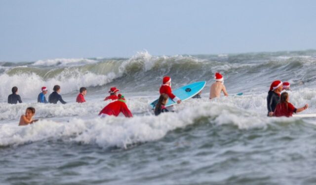 En tablas de surf, Papás Noel toman playa en Florida por diversión y una buena causa (FOTOS)